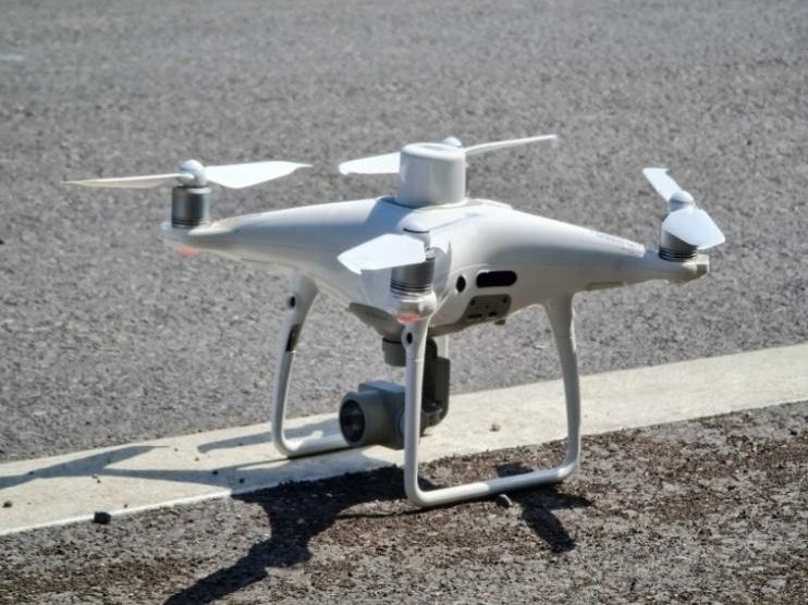 โดรนสำรวจ Phantom 4 RTK สีขาววางบนพื้นถนนก่อนขึ้นบินถ่ายภาพทางอากาศพื้นที่โครงการ