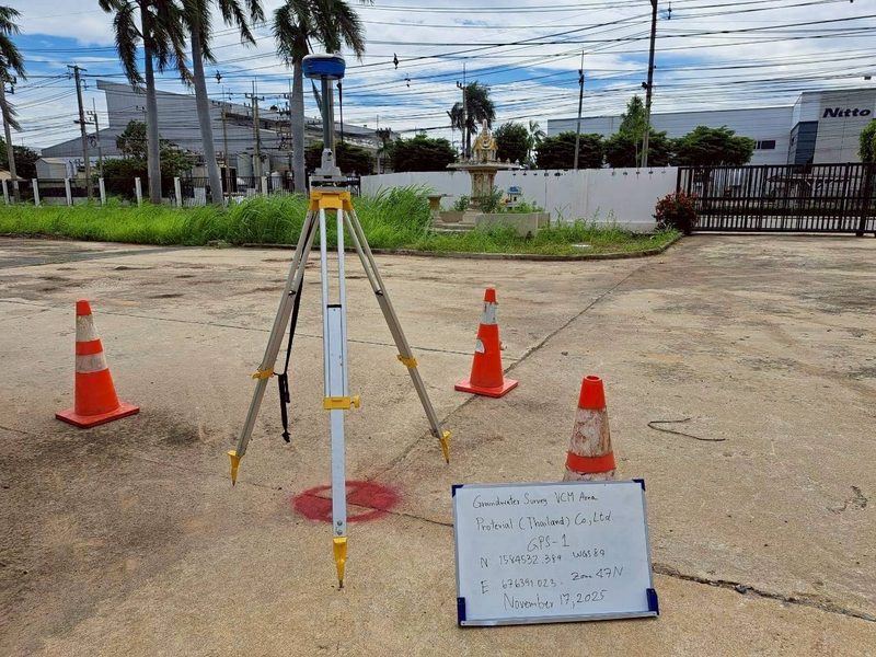 เครื่องรับสัญญาณดาวเทียม GNSS ตั้งบนขาตั้งพร้อมกรวยจราจรและป้ายบันทึกแนวเส้นสำรวจ GPR บนลานคอนกรีต