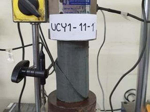 ตัวอย่างดินเหนียวคงสภาพทรงกระบอกกำลังถูกกดในเครื่องทดสอบ Unconfined Compression ในห้องปฏิบัติการทดสอบดิน