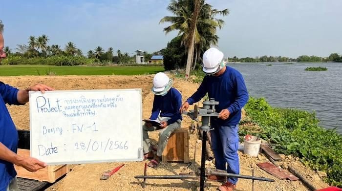 ทีมงาน SPN ทดสอบ Field Vane Shear หลุม FV-1 ริมตลิ่งแม่น้ำ เจ้าหน้าที่หมุนก้านทดสอบเพื่อวัดกำลังรับแรงเฉือนแบบไม่ระบายน้ำของดินเหนียวอ่อน อีกคนบันทึกค่าที่อ่านได้ในสนาม พร้อมป้ายไวท์บอร์ดระบุชื่อโครงการและวันที่ทดสอบ