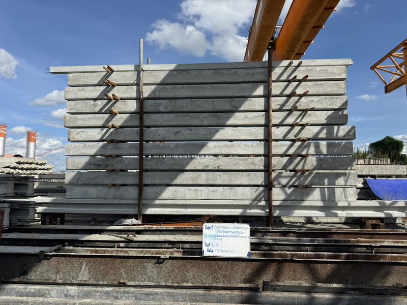 ทดสอบโมเมนต์ดัดเสาเข็มคอนกรีตอัดแรงหน้าตัดไอ 0.45×0.45 ม. ยาว 16 ม. วางแท่งคอนกรีตน้ำหนักถ่วงซ้อนกลางช่วงบนเสาเข็มทดสอบ พร้อมป้ายข้อมูลโครงการคลองระบายน้ำหลากบางบาล–บางไทร