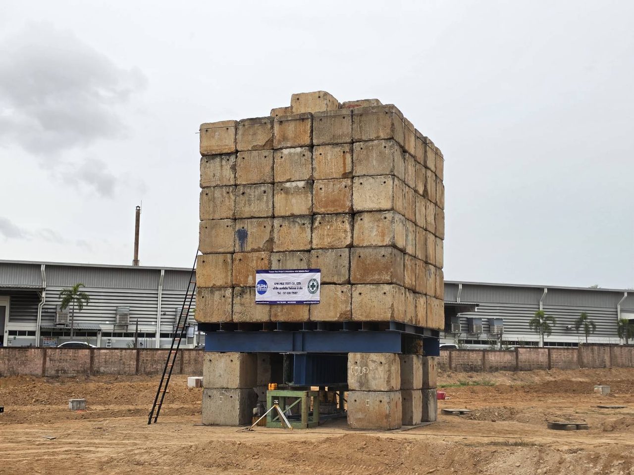 แท่นน้ำหนักถ่วง Kentledge บล็อกคอนกรีตซ้อนเต็มแท่นบน Supporting Beam หน้างานโรงงาน — Static Load Test SPN