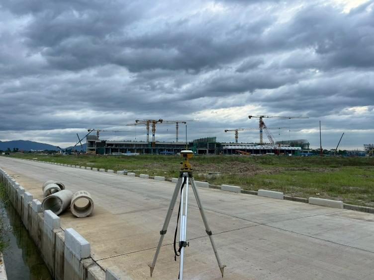 เครื่องรับสัญญาณดาวเทียม GNSS ตั้งบนขาตั้งริมถนน งานรังวัดวางหมุดควบคุมพิกัดโดยทีมสำรวจ SPN